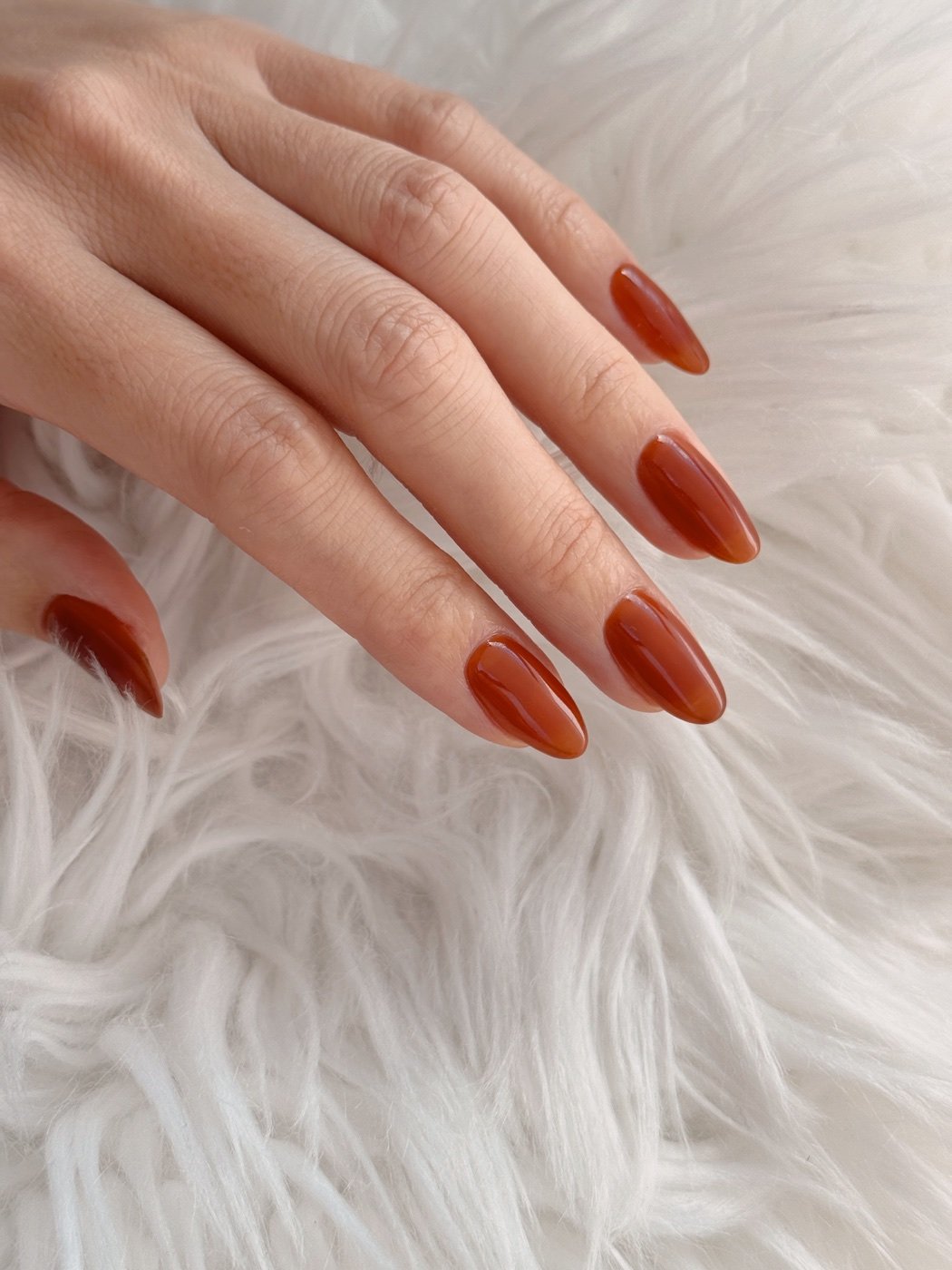 Japanese gel manicure in a rich, glossy rust shade
